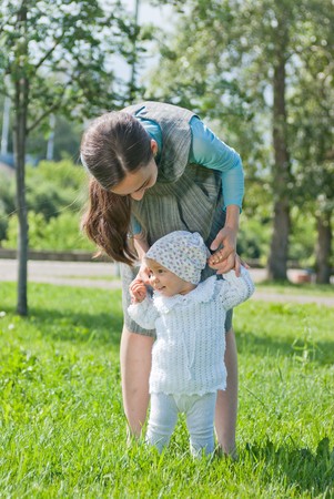 Mom teaches her little daughter to walk, handsの写真素材