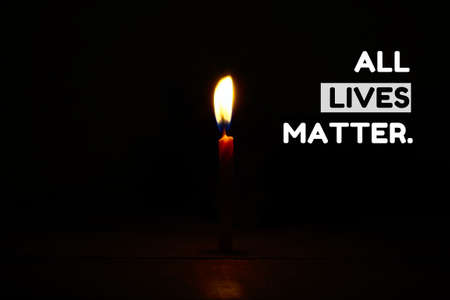 All lives matter text with lighted candle in the dark room as background