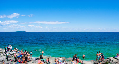 People at the beach with blue and green waterの写真素材