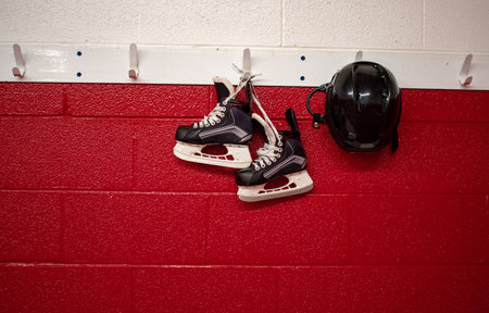 Kids hockey skates and helmet hanging on locker room with copy spaceの写真素材