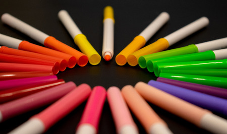 Front view of circle of colorful markers in black background with copy spaceの写真素材