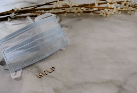 Surgical mask with help sign over marbled background with copy spaceの写真素材