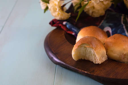 Small bread buns on wooden plate over rustic wooden aqua menthe colored background with copy spaceの写真素材