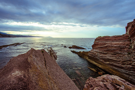 A view of red rocks of Zumaia Flych, Basuqe country Spain at a sunsetの写真素材