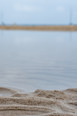 Marine background: ripples of sand and disappearing smoky blue sea water. Copy space.の写真素材