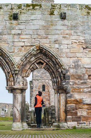 Tourist women taking pictures of the ruins of St Andrews Cathedral , Scotland.の写真素材