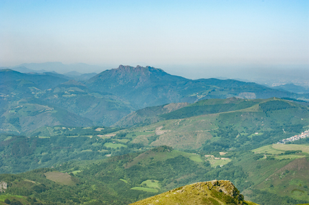 Scenic summer views of the slopes of La Rhune mountain in French Pyrenees lit by sun rays coming from pristine white clouds. Copy space.の写真素材
