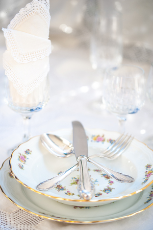 Porcelain plates and silver cutlery and crystal glasses with lace napkins. Selective focus.の写真素材