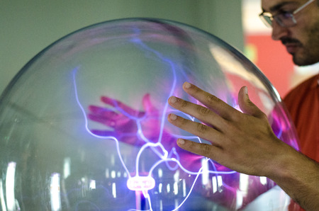 A plasma lamp forming charge filaments from the inner electrode to the outer glass insulator with...