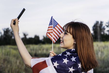 young girl making a self portrait celebrating independence day and having fun with the national flag...