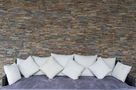 Modern stone wall background texture with purple sofa.の写真素材