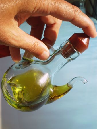 hand pouring oil from an Oil bottleの写真素材