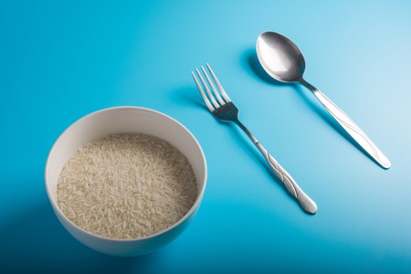 Raw Rice on bowl in blue backgroundの写真素材