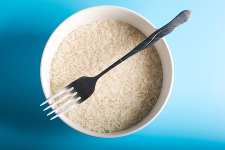 Raw Rice on bowl in blue backgroundの写真素材