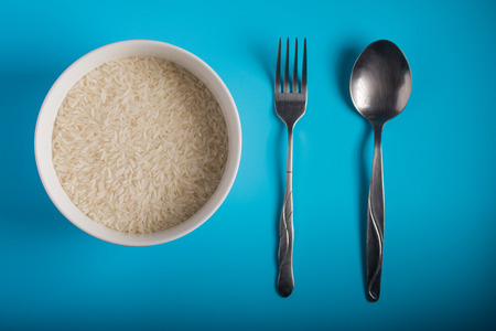 Raw Rice on bowl in blue backgroundの写真素材