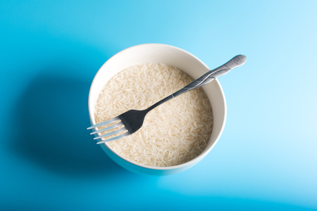 Raw Rice on bowl in blue backgroundの写真素材