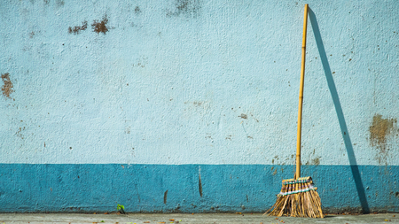 Broom and blue wall
