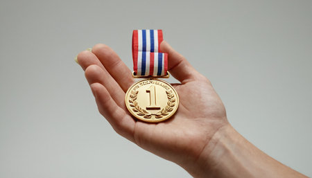 Golden medal with the image of the flag of the United States of America in the hands of a person.の素材