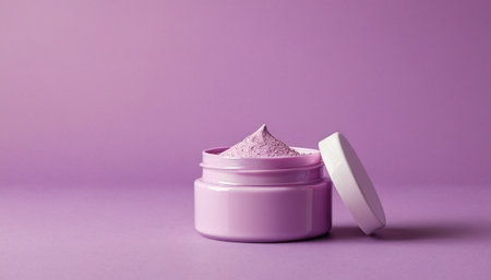 Cosmetic cream in a pink jar on a purple background with copy spaceの素材