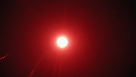 Red light of a red sun on a black background. Abstract backgroundの素材