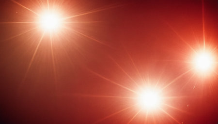 Abstract of sun with lens flare and bokeh effect on red backgroundの素材
