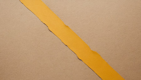 Yellow torn paper with space for text or image on brown background.の素材
