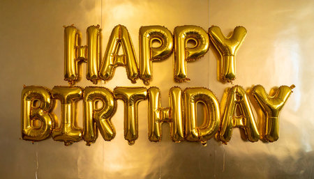 Golden Happy Birthday lettering on golden foil balloon. Party decoration.の素材