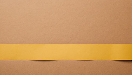 Yellow paper tape on brown background. Copy space for your text.の素材