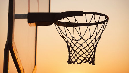 Basketball hoop and net against the sky at sunset, close upの素材