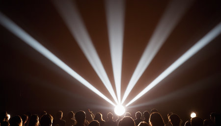 Crowd watching a concert in front of a bright stage with lightsの素材