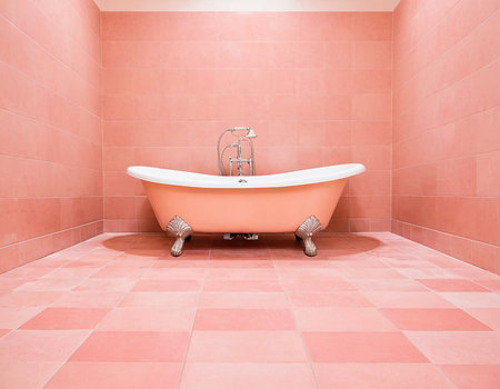 Bathroom interior with pink tile floor and white bathtub.の素材