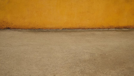 Orange wall and concrete floor in the public park. Abstract background and texture for design.の素材