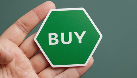 Hands holding a green hexagon with the word BUY.の素材