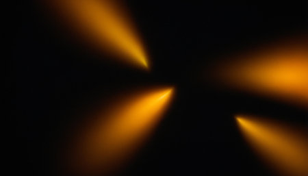 abstract background with yellow rays of light on a black background.の素材