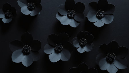 Black paper flowers on black background. Flat lay, top view.の素材