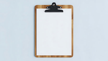 A wooden clipboard with blank white paper is viewed from above against a plain light blue background.の素材