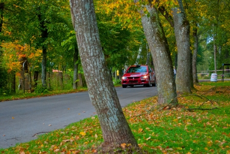 Red racing car in autumn roadのeditorial素材