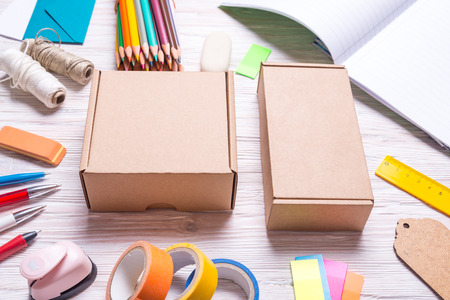 Set of cardboard boxes and stationery on a wooden background, top view