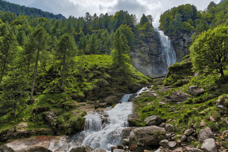 Big Waterfall in the forest, spring season near the little ancient village of Sonogno in Switzerlandの写真素材