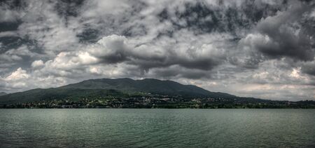 Cloudy sky over the lake of Varese in a spring afternoonの写真素材
