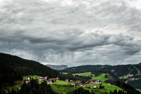 Storm clouds over the little village of Gardena Valley, Alto Adige, Italyの写真素材