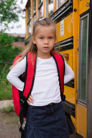 Little Pre-teen Schoolgirl Waiting for Schoolbus to open a Doorの写真素材