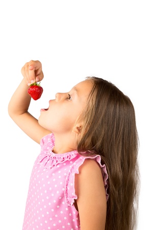 Beautiful young girl with long hair posing with fresh strawberry, isolatedの写真素材