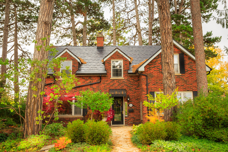 Old House Surrounded by Tall Trees in Autumnの写真素材