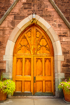 Entrance door to a cathedral, with flower pots on both sidesの写真素材