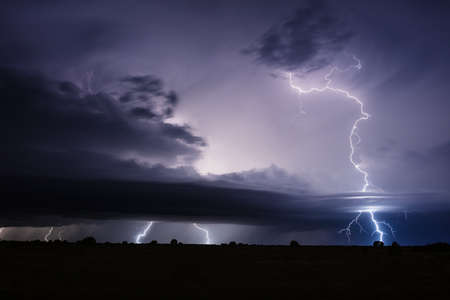 Thunderstorm with lightning bolt strikes and dramatic storm clouds.の写真素材