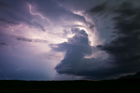Supercell thunderstorm cloud illuminated by lightning