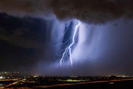 A lightning bolt strikes through a microburst in a stormの写真素材