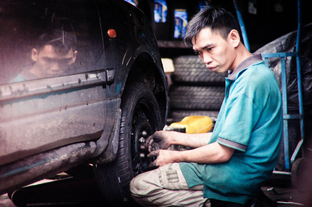 The car mechanic on job,fixing tyre.のeditorial素材