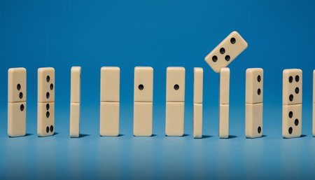 Domino effect on blue background. Concept of domino effect.の素材